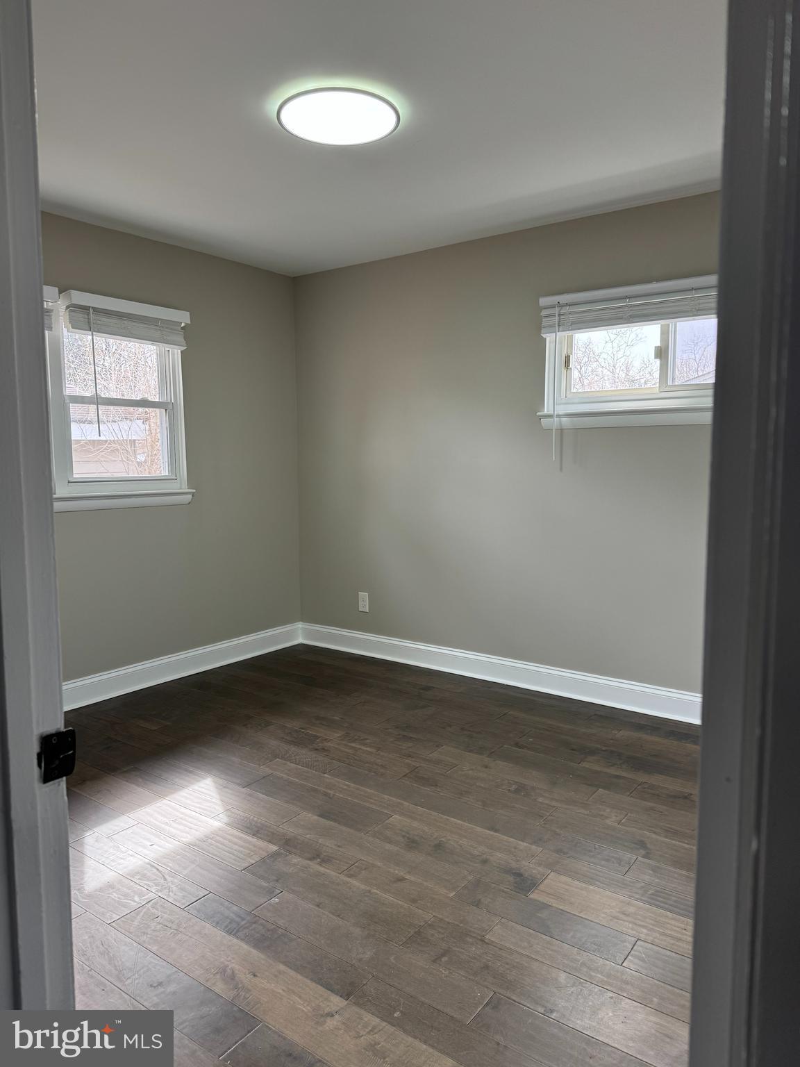 8313 26th Avenue Adelphi, MD 20783 - Photo 5 of 17 an empty room with wooden floor and windows
