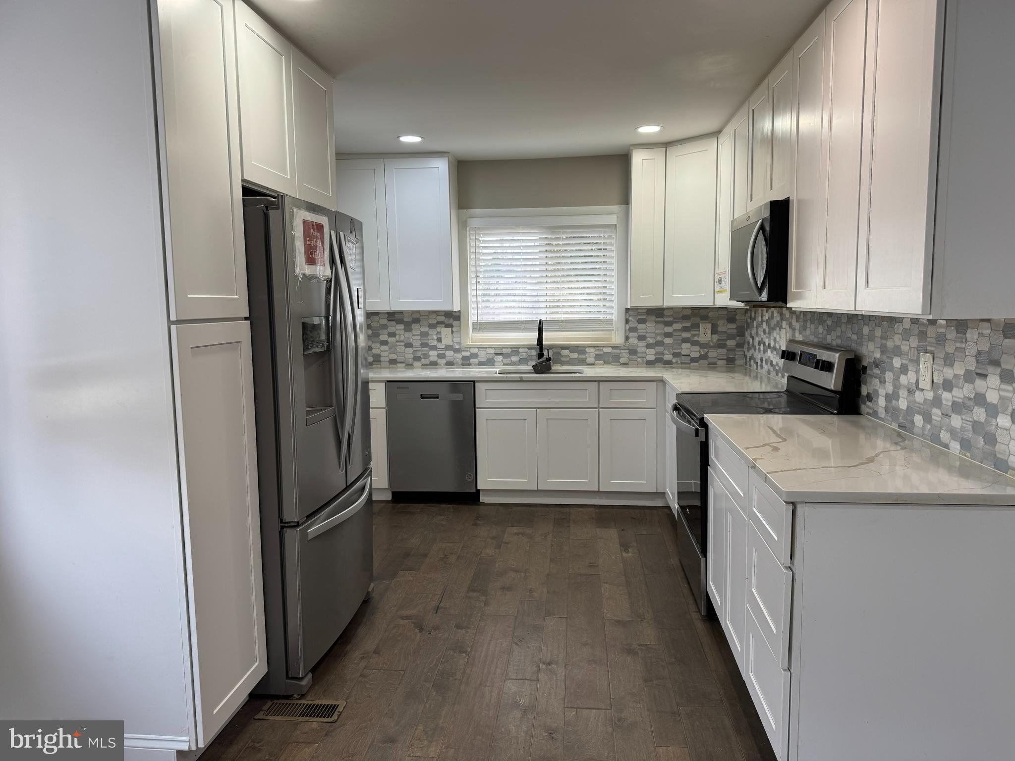 8313 26th Avenue Adelphi, MD 20783 - Photo 8 of 17 a kitchen with stainless steel appliances granite countertop a refrigerator a stove a sink and a microwave