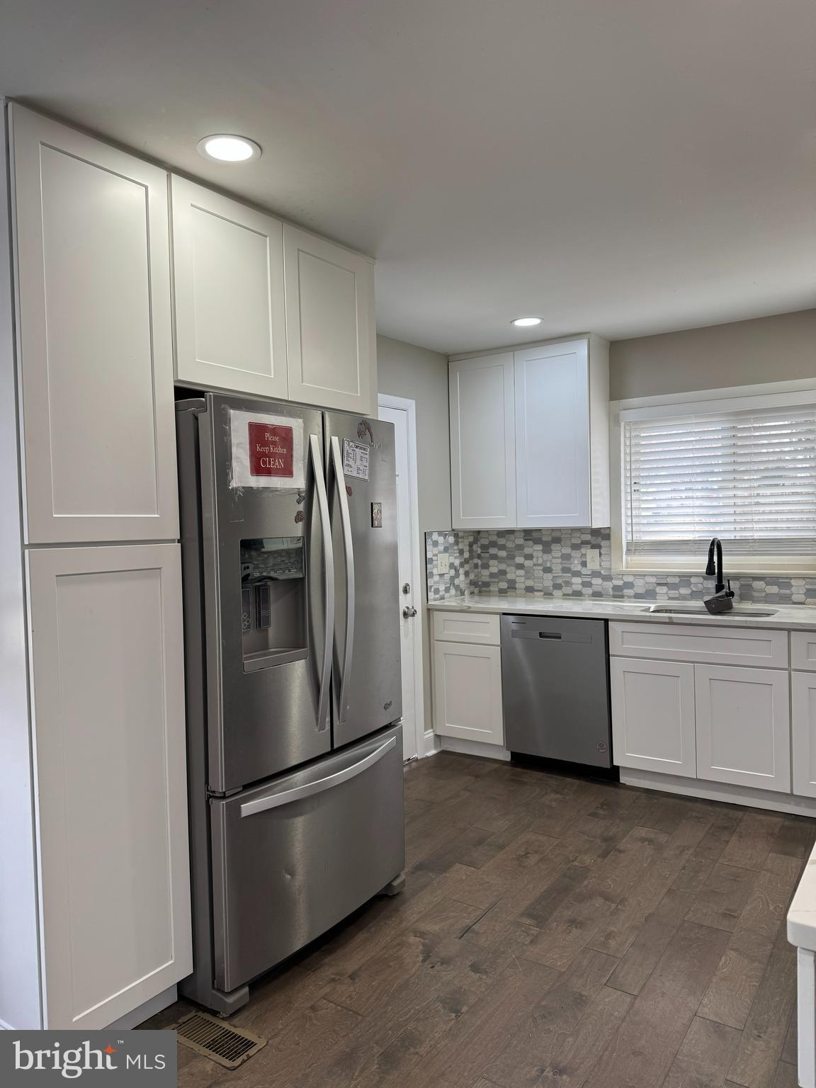 8313 26th Avenue Adelphi, MD 20783 - Photo 9 of 17 a large kitchen with a refrigerator a sink and cabinets
