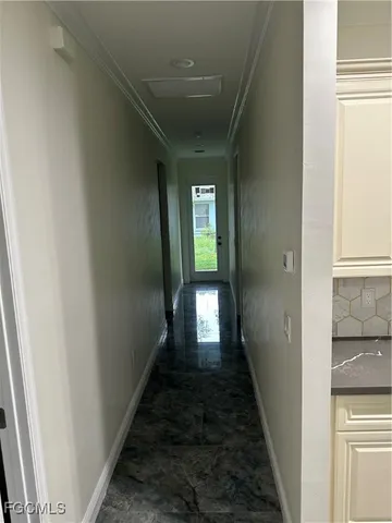 a hallway with wooden floor table and chairs