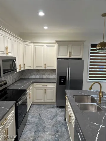 a kitchen that has a sink cabinets counter space and stainless steel appliances
