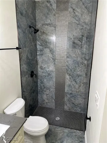 a bathroom with a toilet and a shower