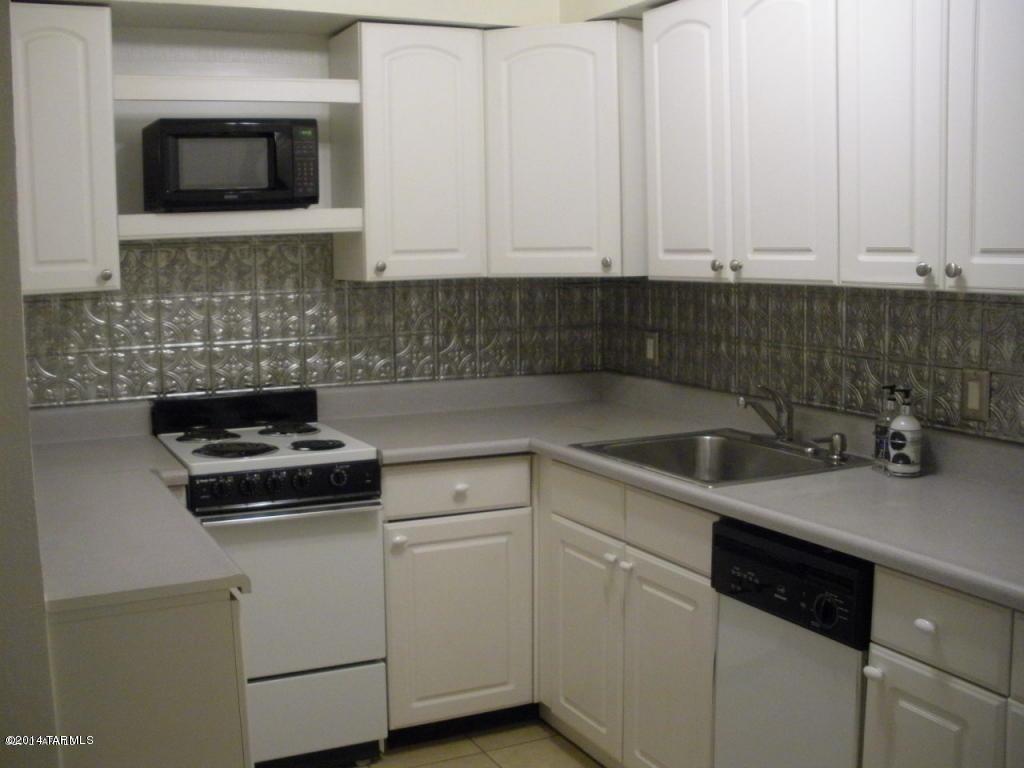 1600 North Wilmot Road, Unit 245 Tucson, AZ 85712 - Photo 2 of 12 a kitchen with white cabinets and white appliances