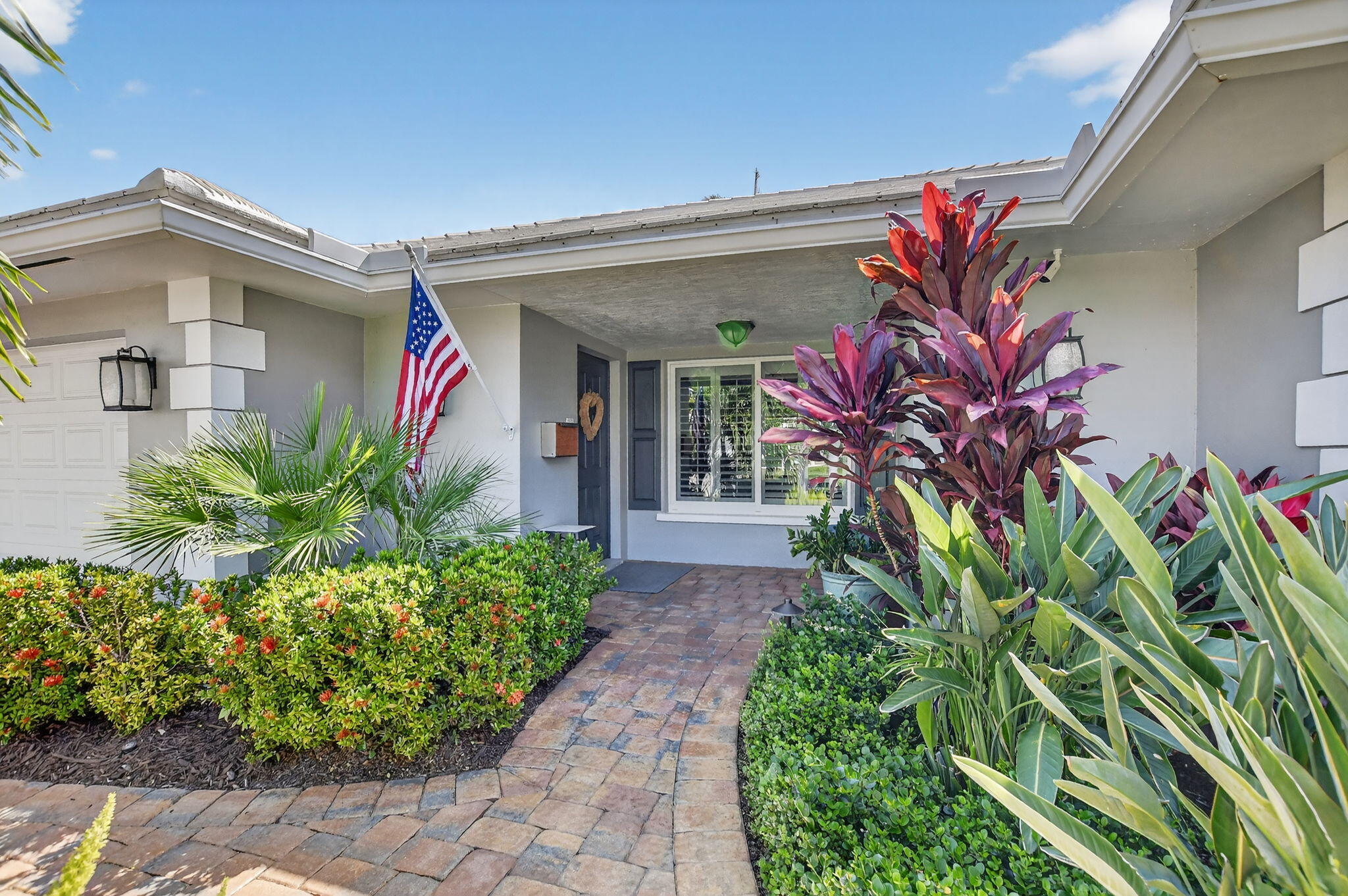 1388 Walnut Terrace Boca Raton, FL 33486 - Photo 3 of 74 a front view of a house with a flower garden