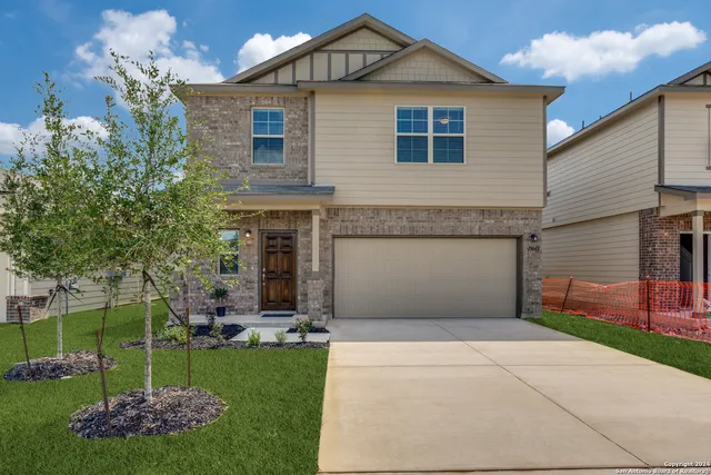 a front view of a house with a garden and plants