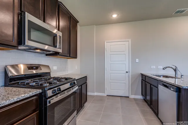 a kitchen with stainless steel appliances granite countertop a stove and a microwave