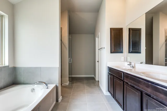 a bathroom with a tub sink and mirror