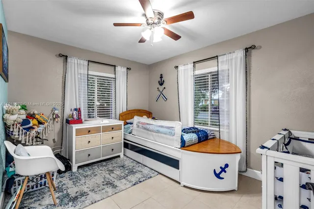 a view of a backyard with table and chairs potted plants and large tree