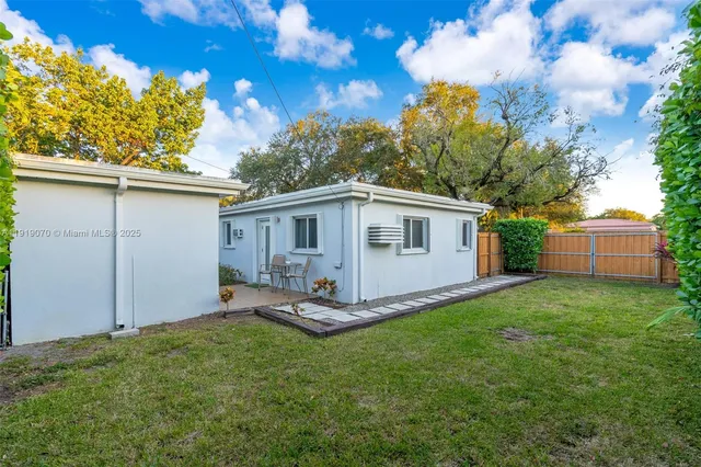 an aerial view of residential houses with outdoor space and ocean view