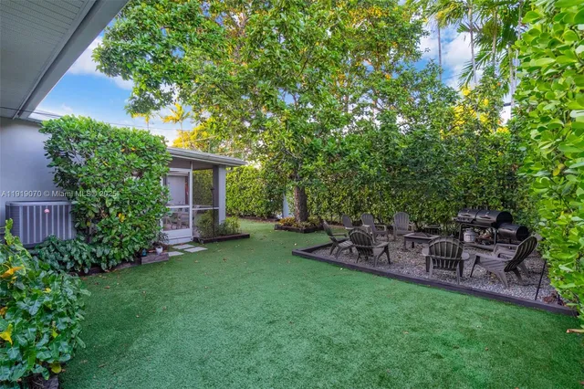 an aerial view of residential houses with outdoor space and trees