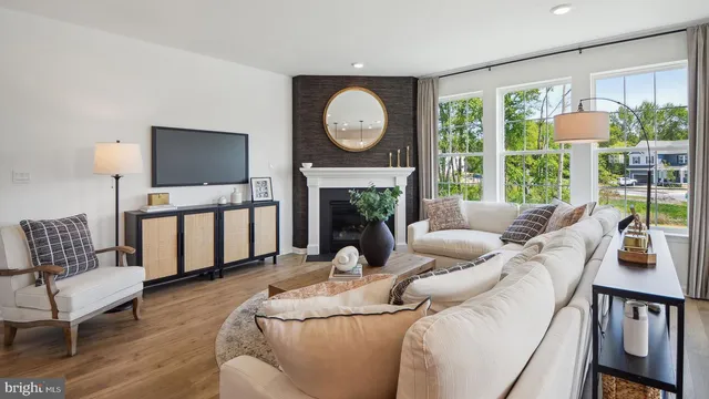 a living room with furniture a fireplace and a floor to ceiling window