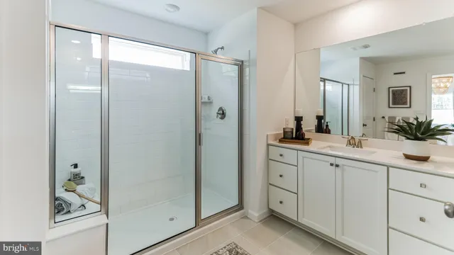 a spacious bathroom with a shower sink and mirror