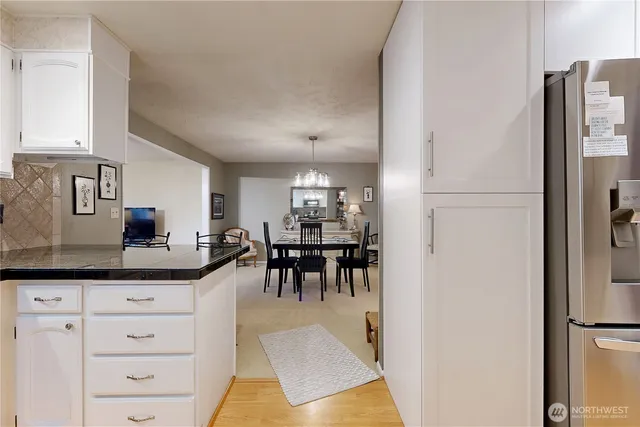 a kitchen with stainless steel appliances kitchen island granite countertop a refrigerator and cabinets