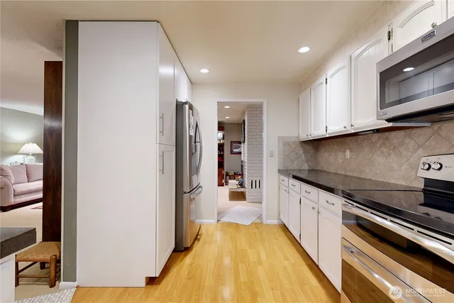 a kitchen with stainless steel appliances granite countertop a refrigerator and microwave