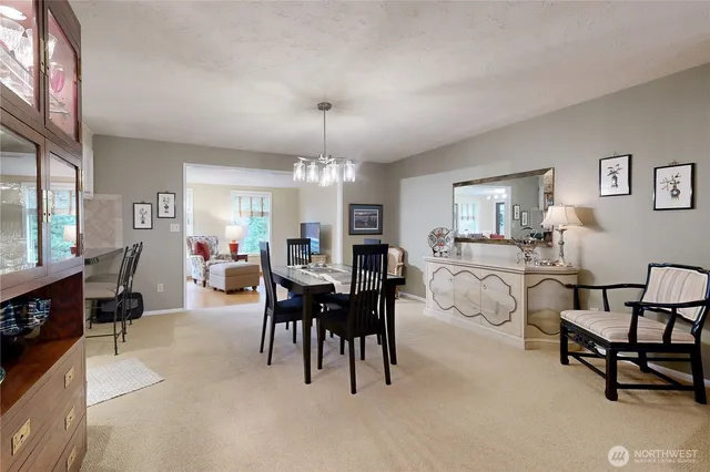 a living room with furniture a dining table and a chandelier