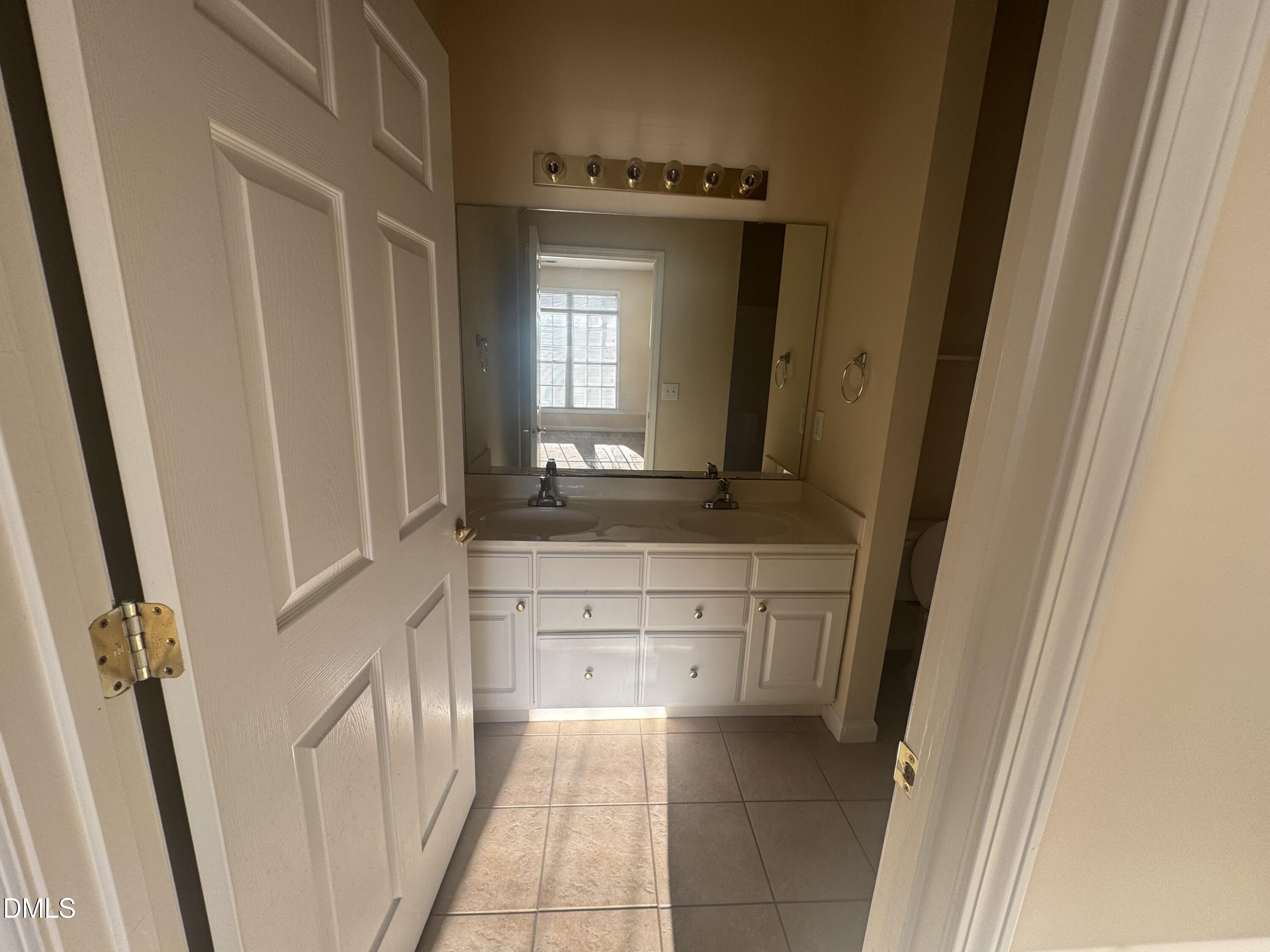2510 Friedland Place, Unit 202 Raleigh, NC 27617 - Photo 23 of 25 a bathroom with a sink a mirror and a vanity