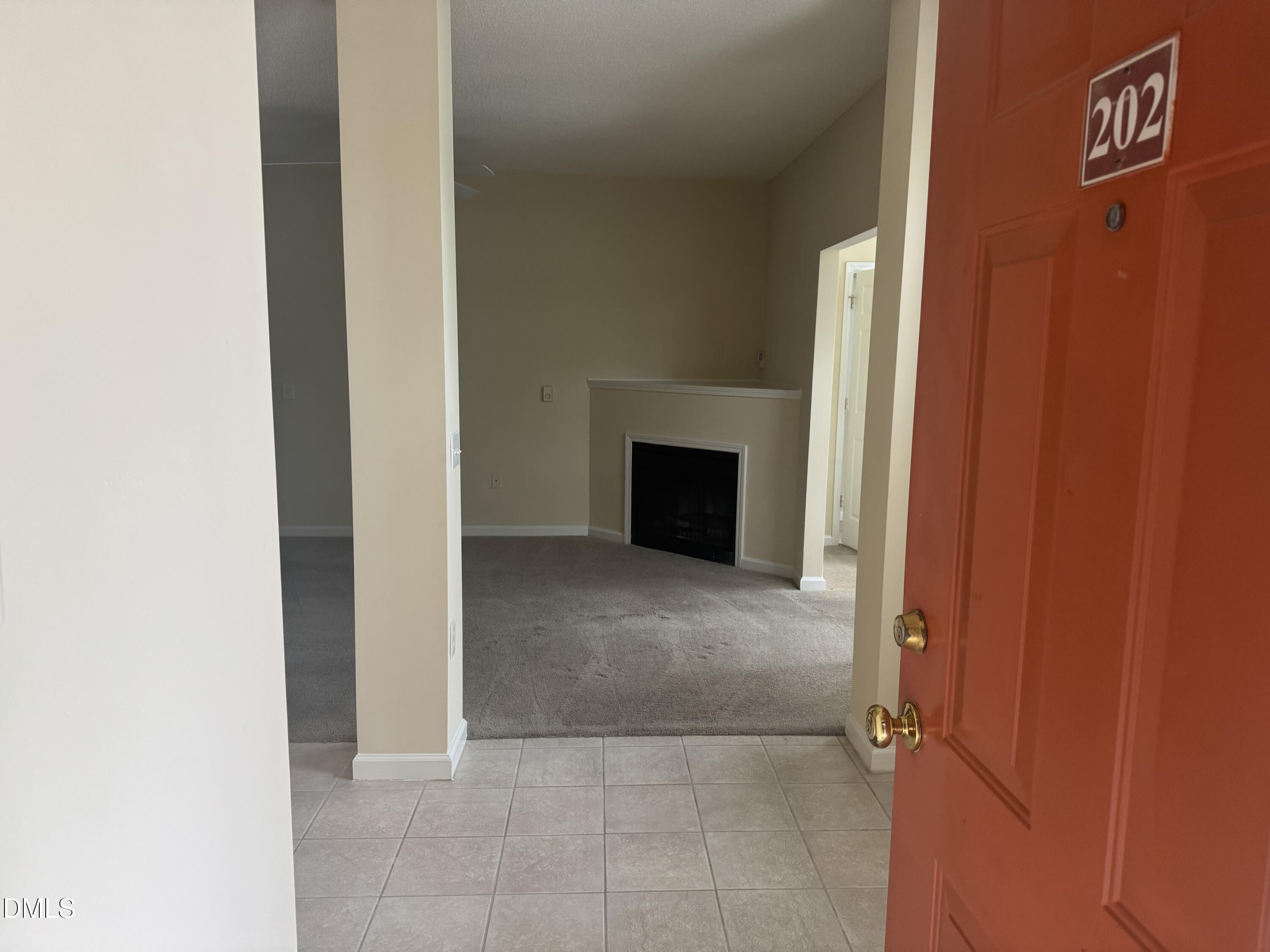 2510 Friedland Place, Unit 202 Raleigh, NC 27617 - Photo 4 of 25 a view of an empty room with a fireplace and a window