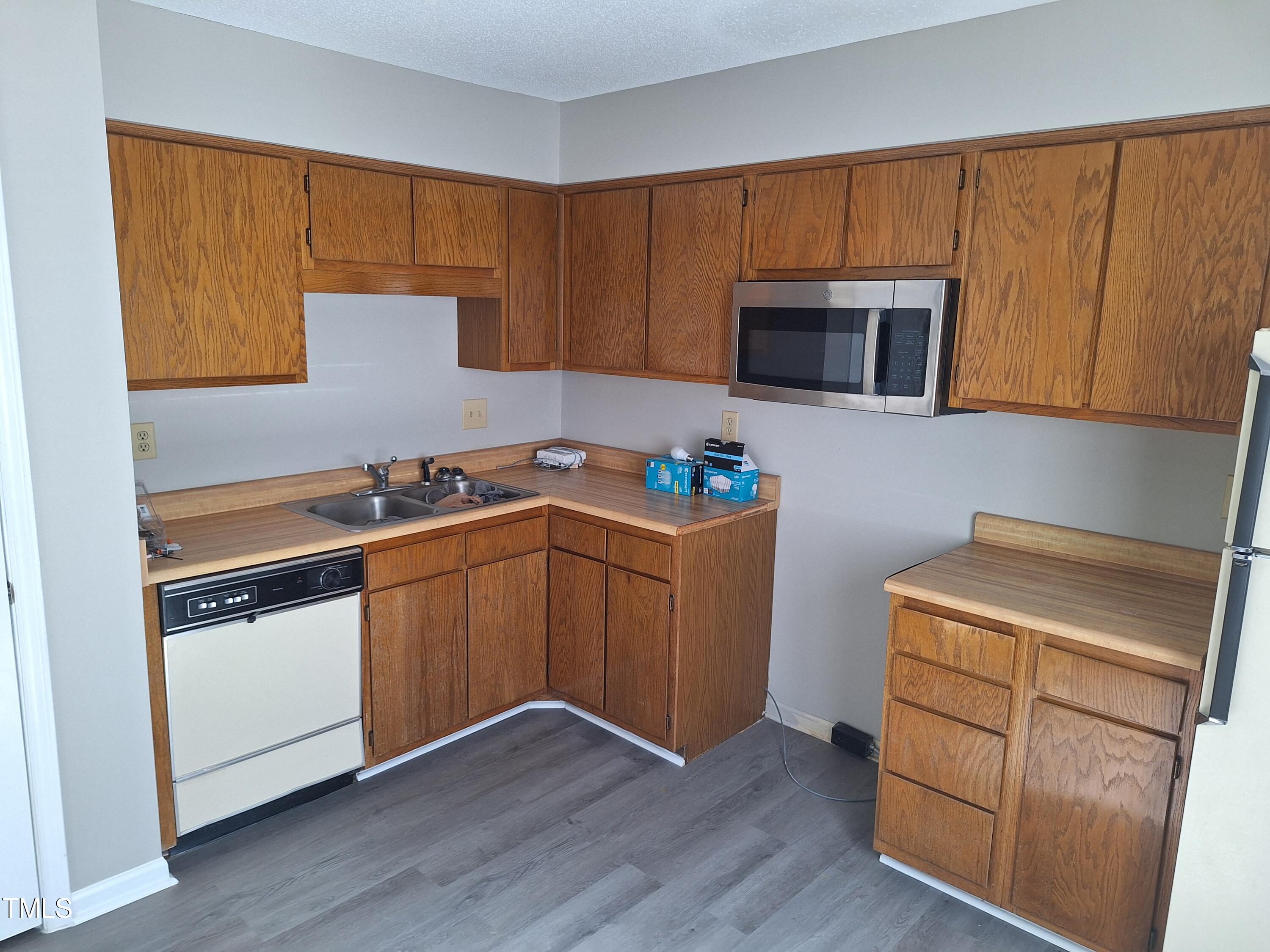 322 Junction Road, Unit 29B Durham, NC 27703 - Photo 4 of 12 a kitchen with granite countertop cabinets stainless steel appliances and wooden floor
