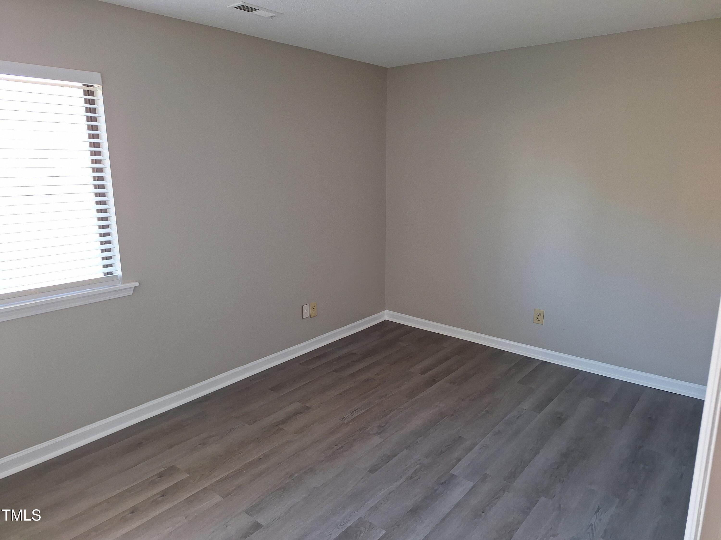 322 Junction Road, Unit 29B Durham, NC 27703 - Photo 10 of 12 a view of an empty room with wooden floor and a window