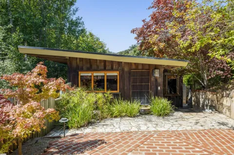 a living room with furniture a fireplace and a floor to ceiling window