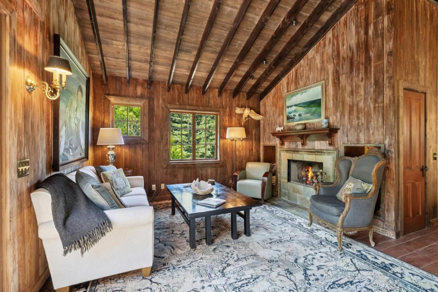 10026 Sycamore Canyon Road Big Sur, CA 93920 - Photo 45 of 67 a living room with furniture a fireplace and a table