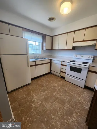 a kitchen with stainless steel appliances granite countertop a refrigerator a stove and a sink