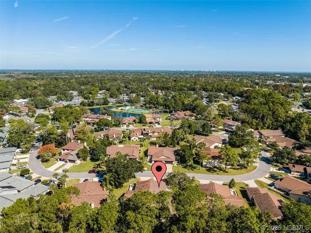 an aerial view of a house with a garden and lake view