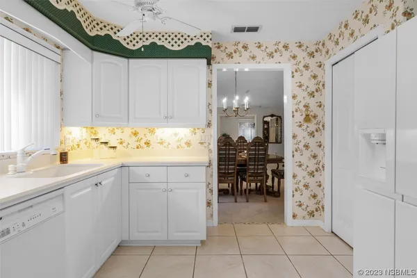 a kitchen with a table chairs and white cabinets