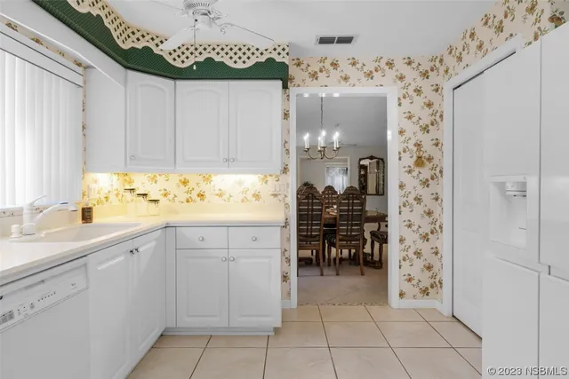 a kitchen with a table chairs and white cabinets