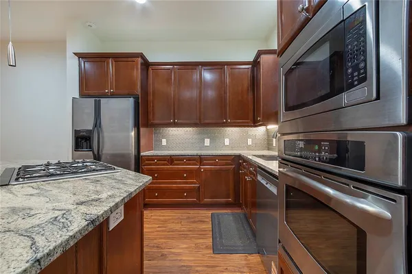a kitchen with granite countertop stainless steel appliances and wooden cabinets