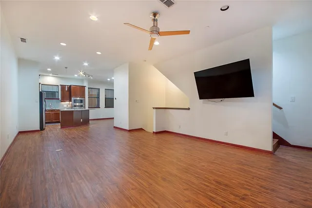 a view of an empty room with wooden floor