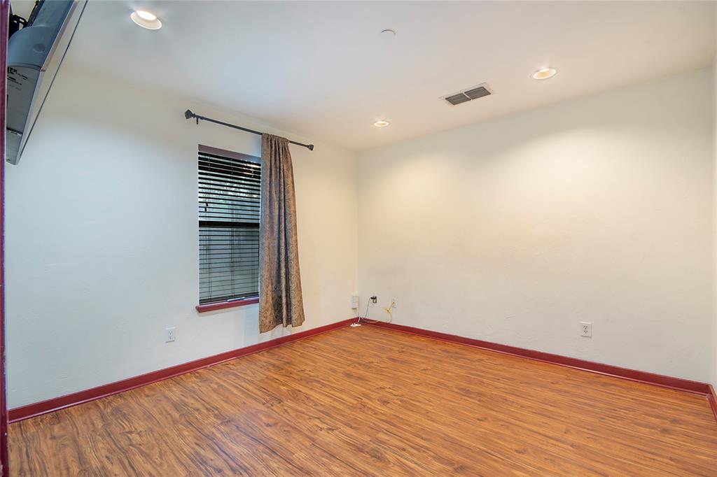 1016 Liberty Street, Unit 4 Dallas, TX 75204 - Photo 20 of 33 an empty room with wooden floor and windows