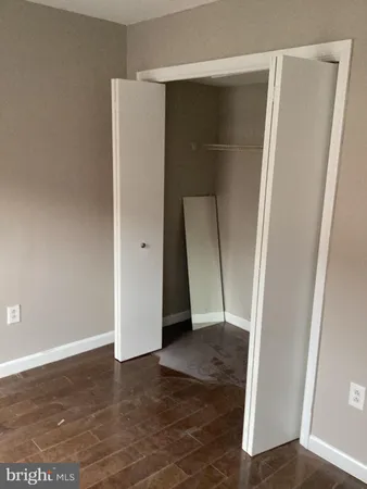 an empty room with wooden floor and entrance