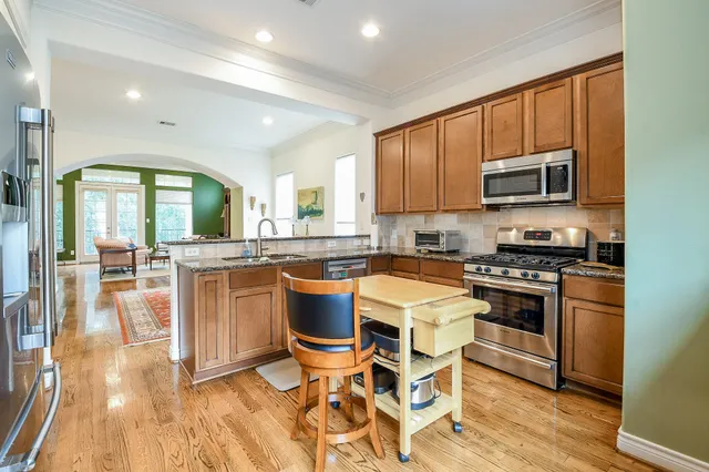 a kitchen with stainless steel appliances kitchen island granite countertop a stove a sink and a microwave