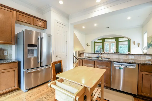 a kitchen with stainless steel appliances granite countertop a refrigerator a sink and a stove