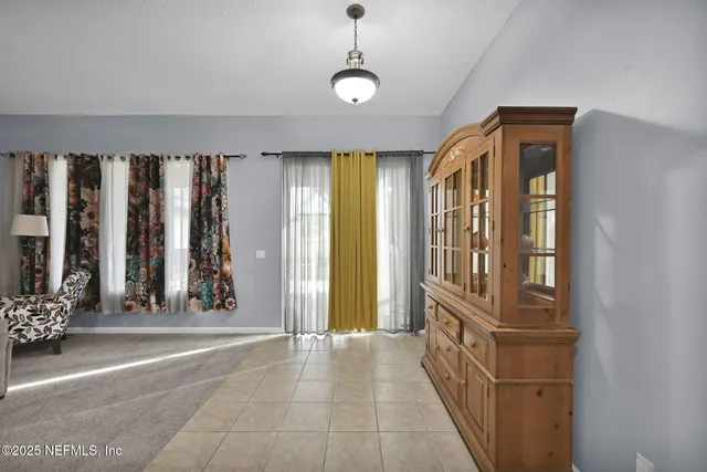 a view of a hallway with windows and chandelier