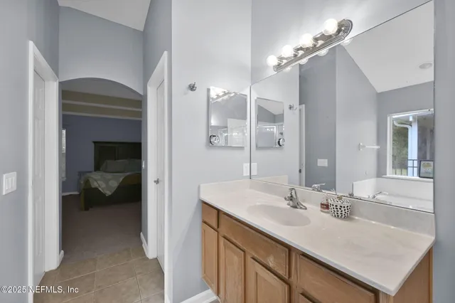 a en suite bathroom with a sink a large mirror and vanity