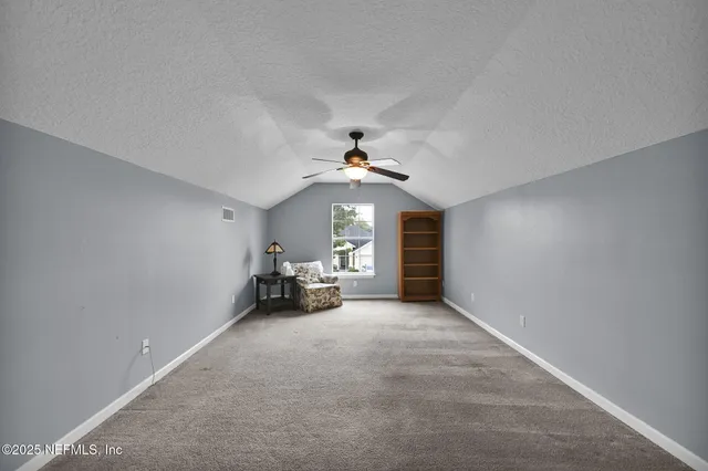 a view of a livingroom with a ceiling fan and window