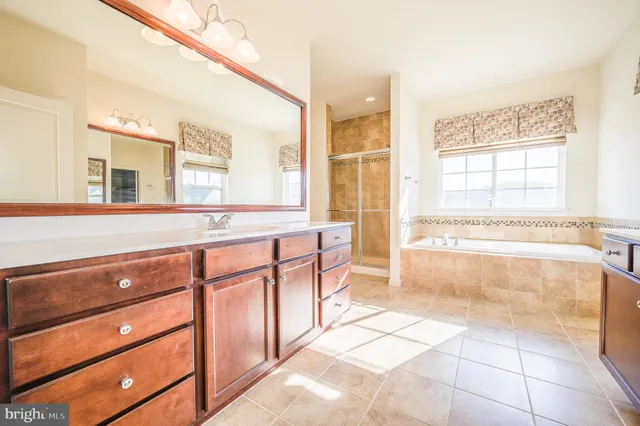 a spacious bathroom with a tub sink and mirror