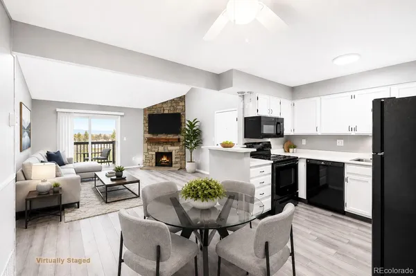 a living room with stainless steel appliances furniture and a flat screen tv