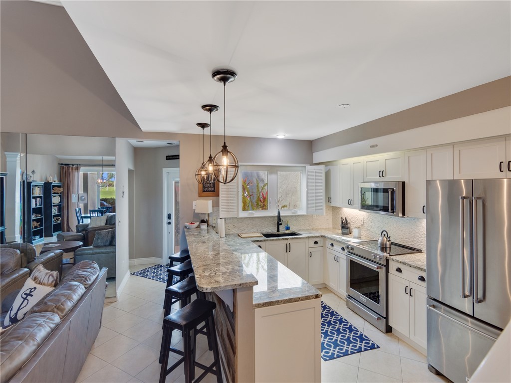 1370 St Davids Lane Vero Beach, FL 32967 - Photo 12 of 36 a kitchen with stainless steel appliances granite countertop a sink stove and refrigerator