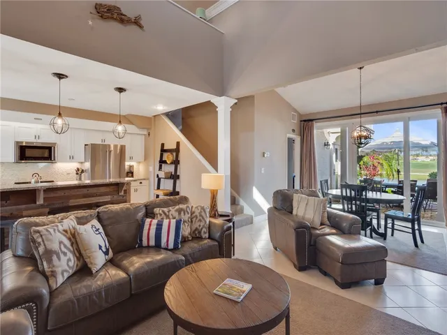 a living room with furniture kitchen view and a large window