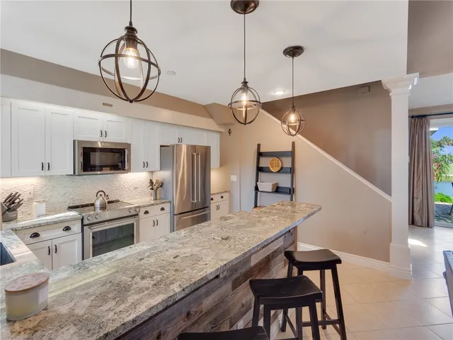 a kitchen with stainless steel appliances granite countertop a stove refrigerator and microwave