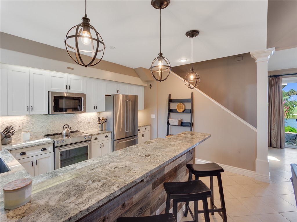 1370 St Davids Lane Vero Beach, FL 32967 - Photo 10 of 36 a kitchen with stainless steel appliances granite countertop a stove refrigerator and microwave