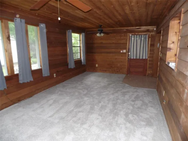 a view of an empty room with a fireplace and a window