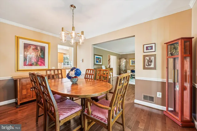 a dining room with furniture a chandelier and wooden floor