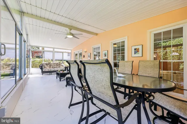 a dining room with furniture and a floor to ceiling window