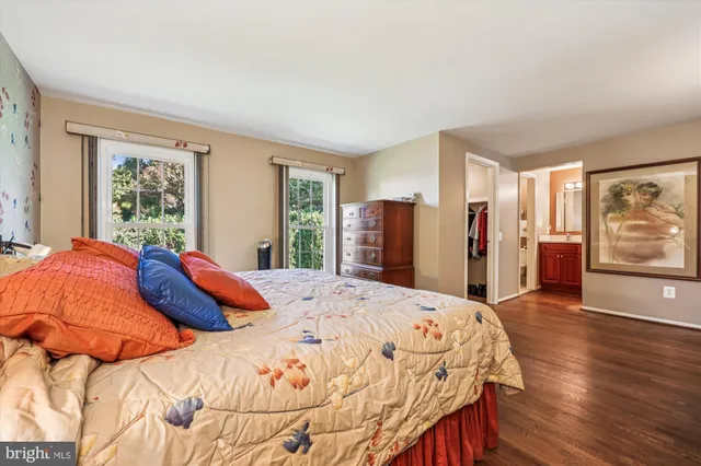 a spacious bedroom with a bed and wooden floor