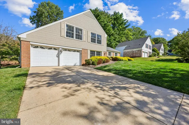 a view of a yard in front of a house with large tree