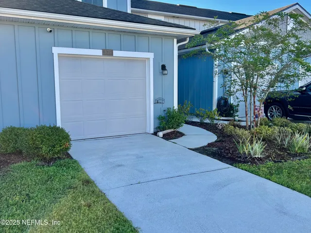 a backyard of a house with plants and outdoor seating